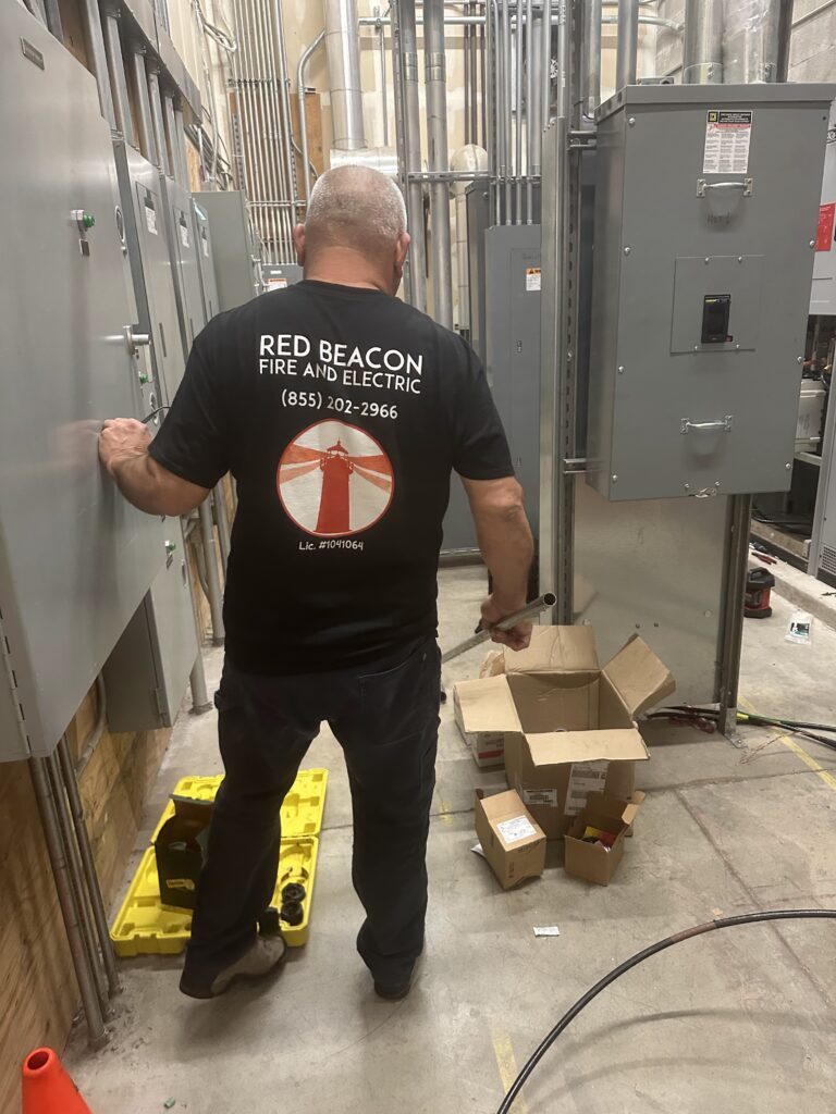A Red Beaon Technician working on an electrical panel upgrade